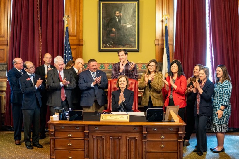 Governor signing legislation with supporters